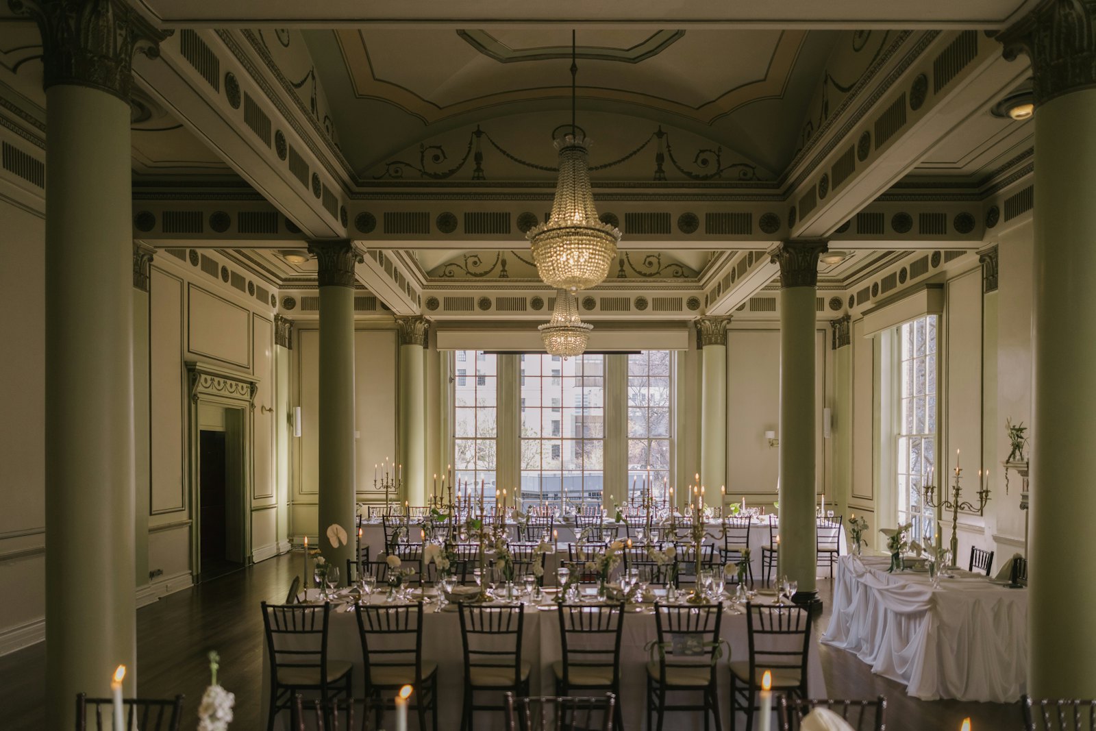 Elegant ballroom set with long tables and chandeliers